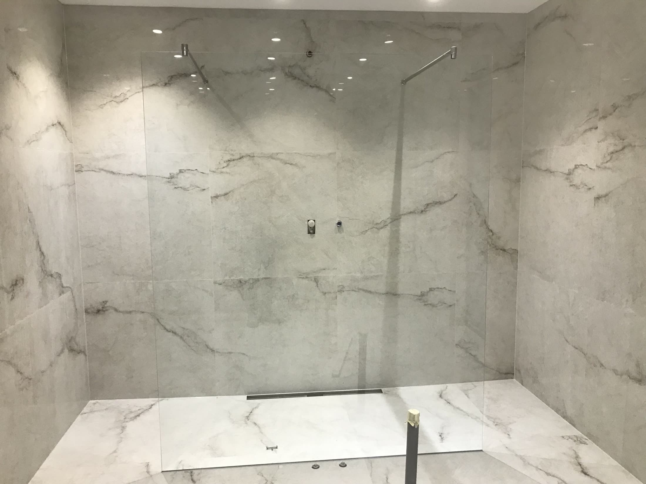 Modern shower enclosure with marble-look tiles